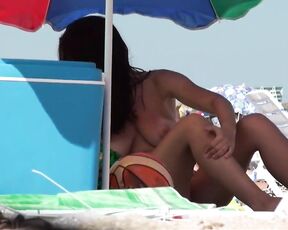 Süße vollbusige Brünette mit Bräunungsstreifen und großen Möpsen am Strand